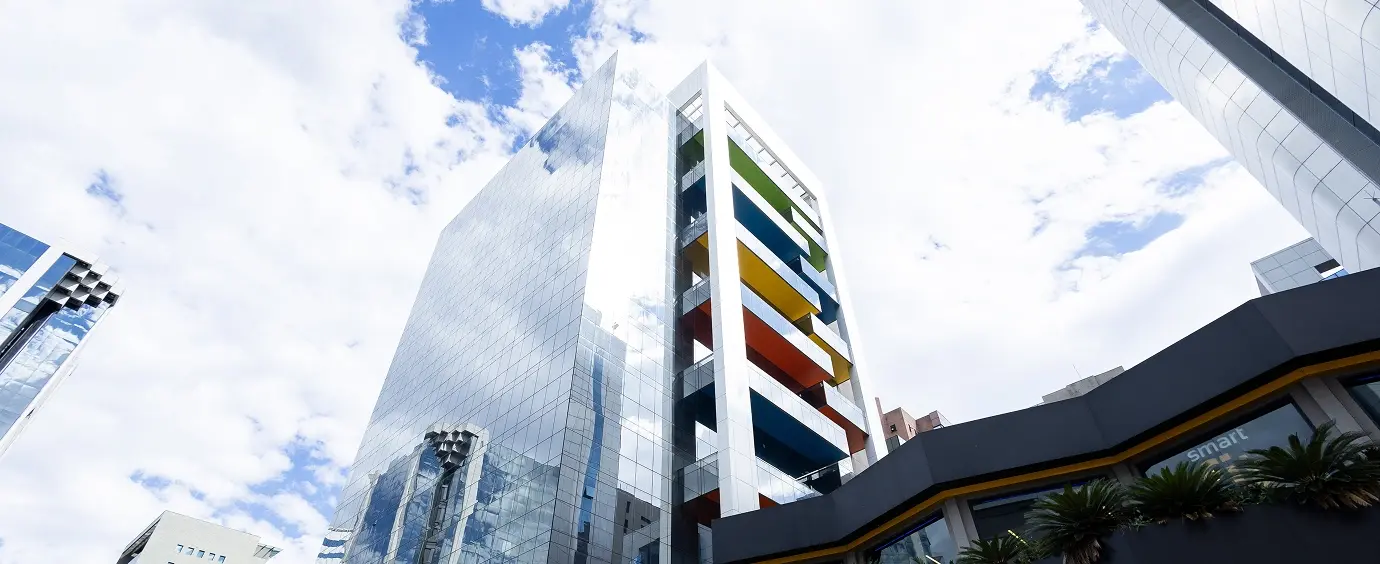 Prédio do Cubo Itaú visto de baixo, com as sacadas coloridas